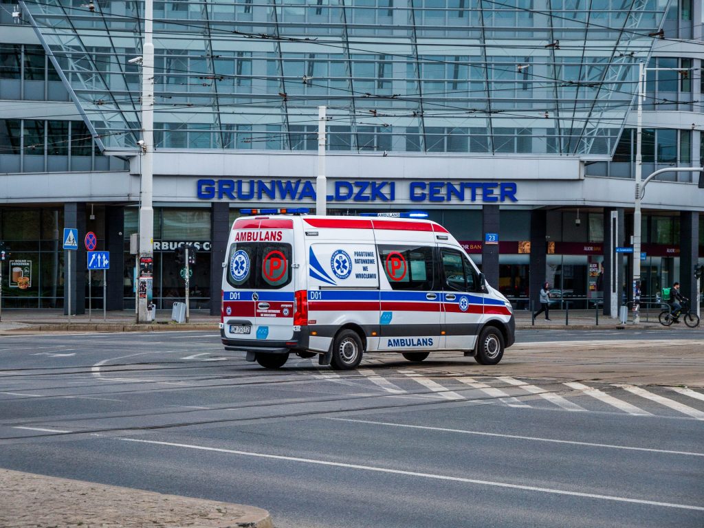 Ambulance driving on street near Grunwaldzki Center in Wrocław, Poland.